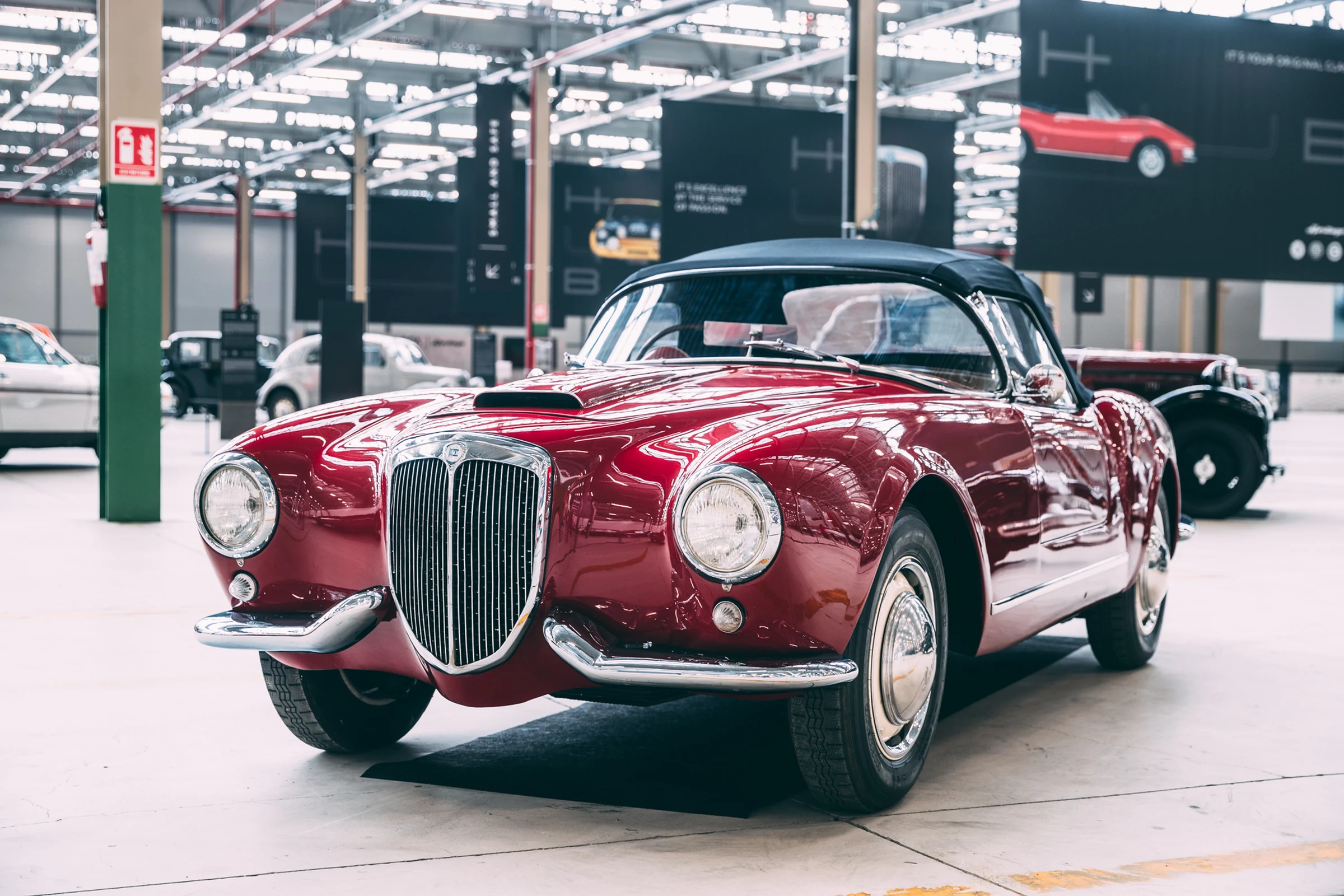 Lancia Aurelia convertible granate de los años cincuenta, expuesto en el Heritage Hub de Turín