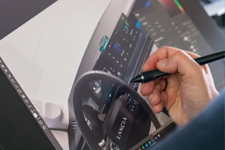 Mano de un diseñador de Lancia dibujando con un lápiz digital el interior de un auto, imagen de los Lancia Design Days