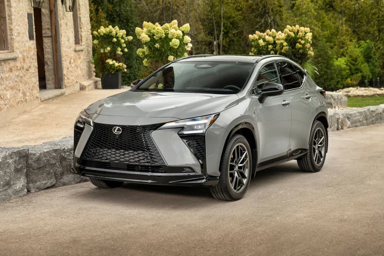 Lexus NX 2027 350h F SPORT en color gris Incognito, visto de frente en tres cuartos, frente a un edificio de piedra