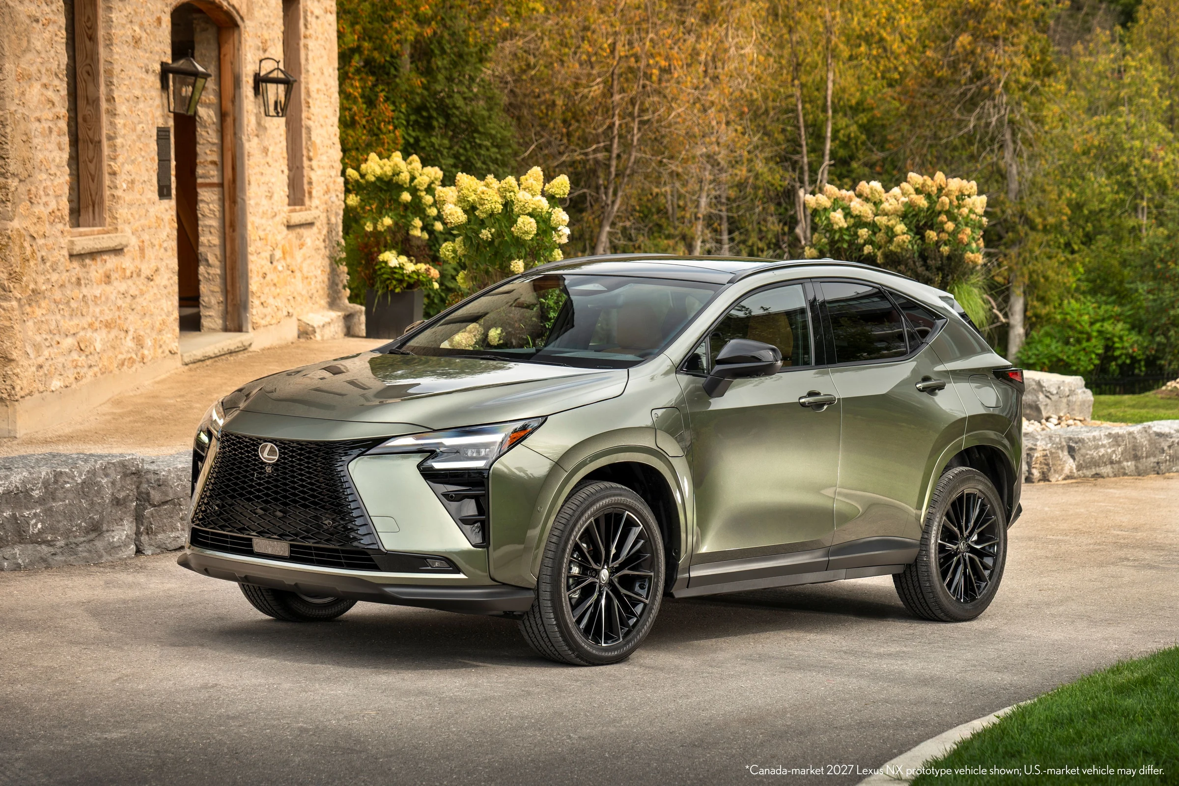 Lexus NX 2027 450h+ enchufable en color verde Shaded Ivy, visto de frente en tres cuartos, frente a un edificio de piedra