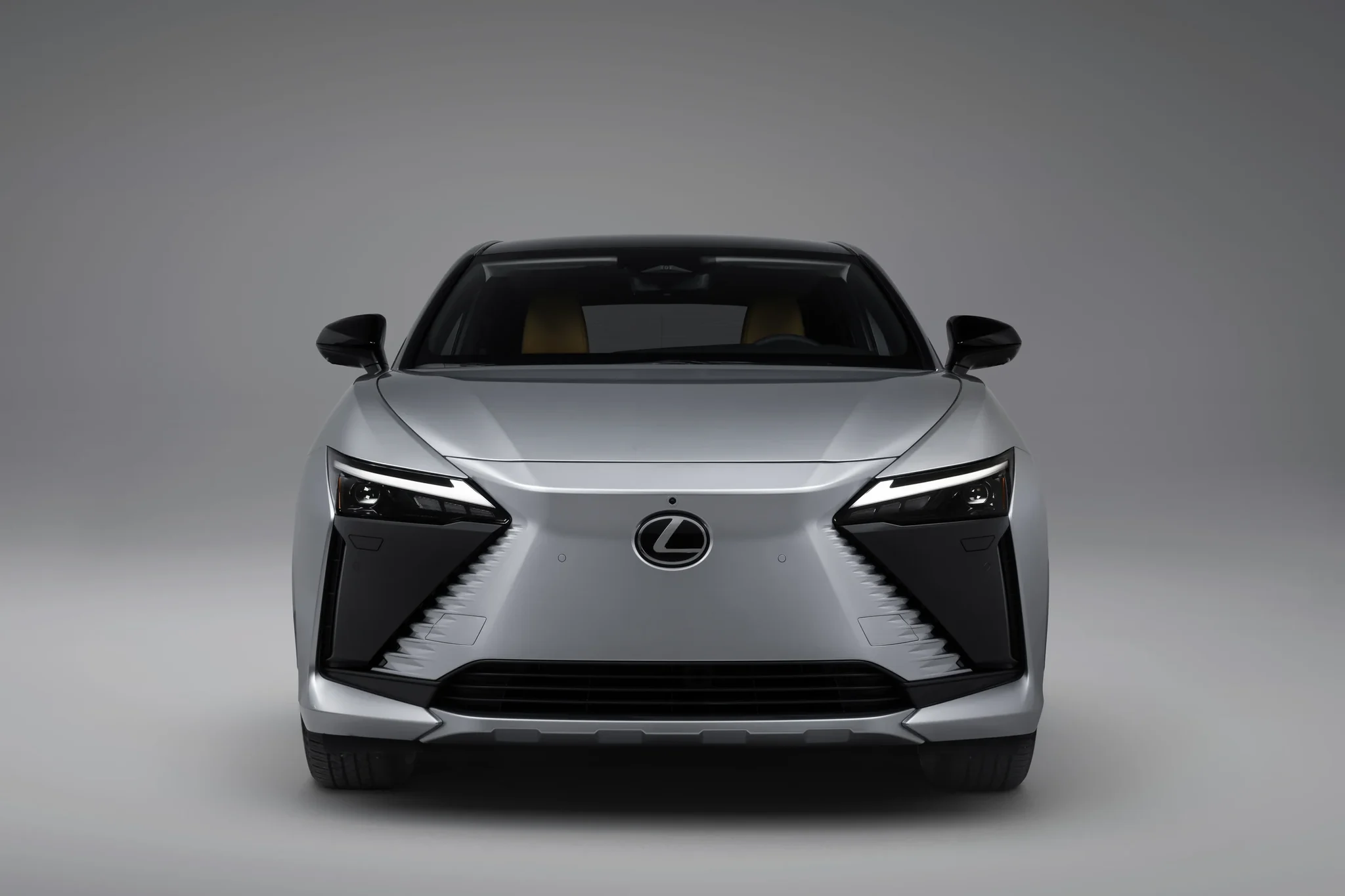 Frente del Lexus RZ 350e FWD gris, con la parrilla en forma de huso y los faros afilados