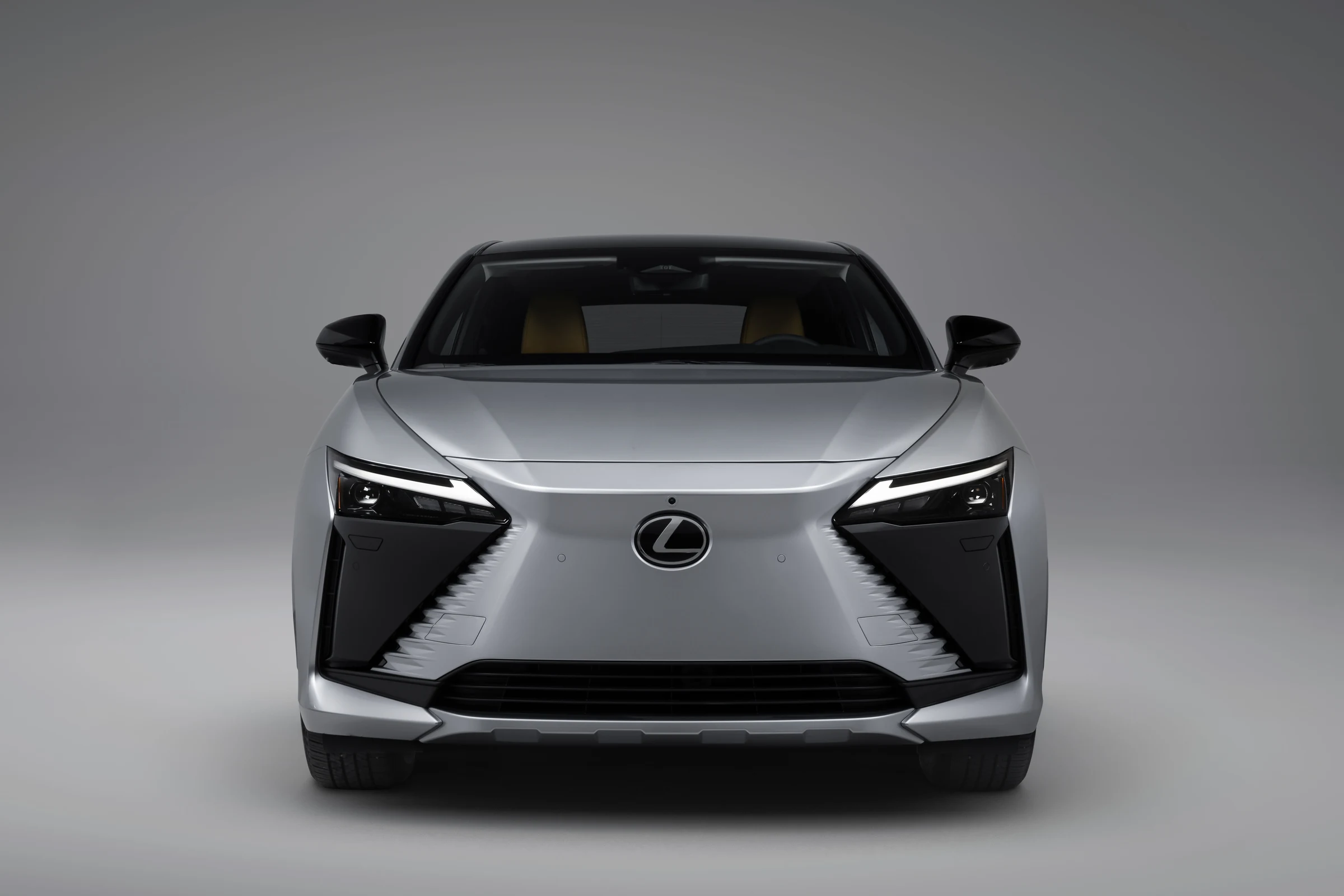 Frente del Lexus RZ 350e FWD gris, con la parrilla en forma de huso y los faros afilados