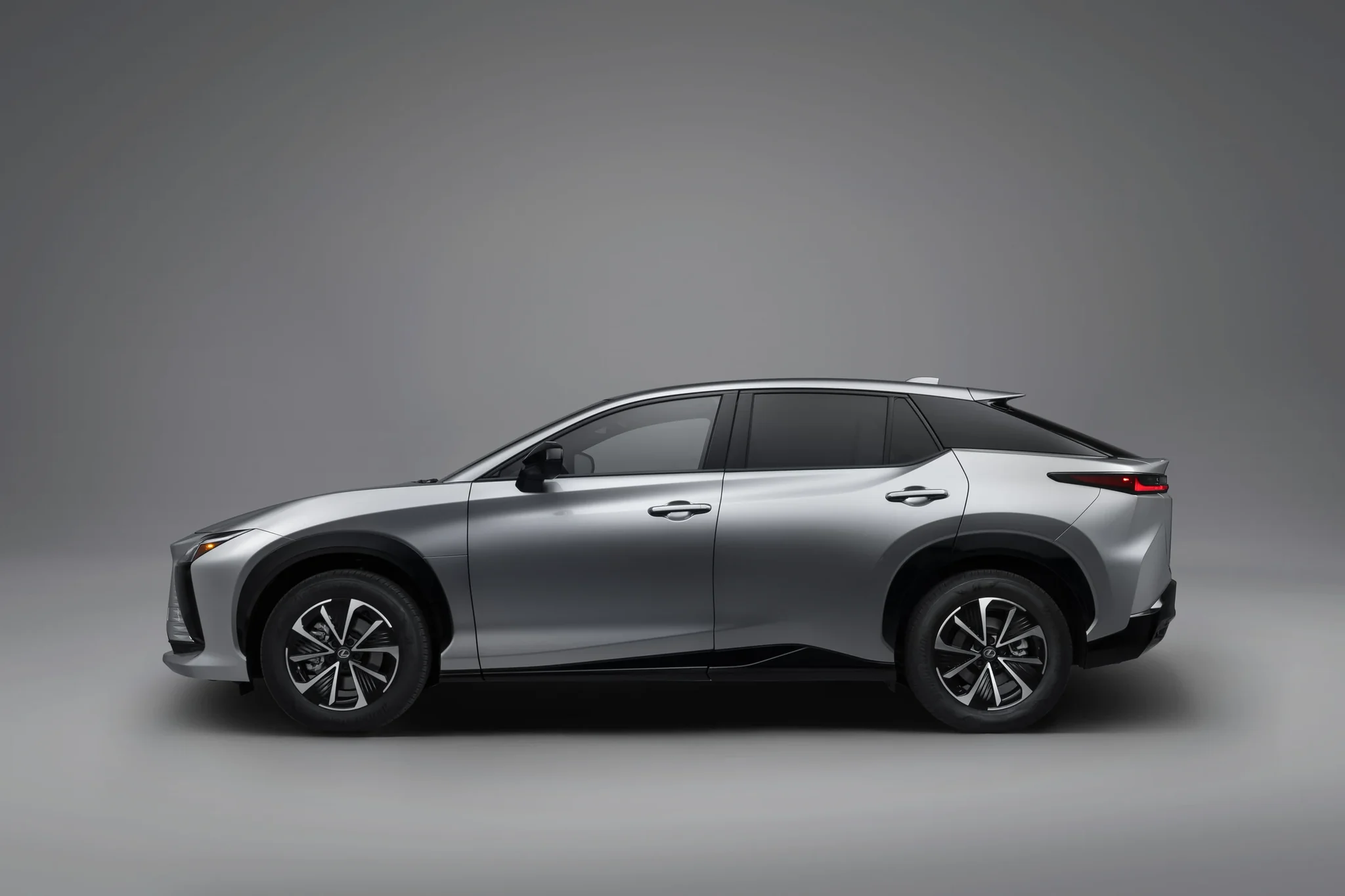 Perfil del Lexus RZ 350e FWD gris, con la línea del techo descendente y los rines de 18 pulgadas