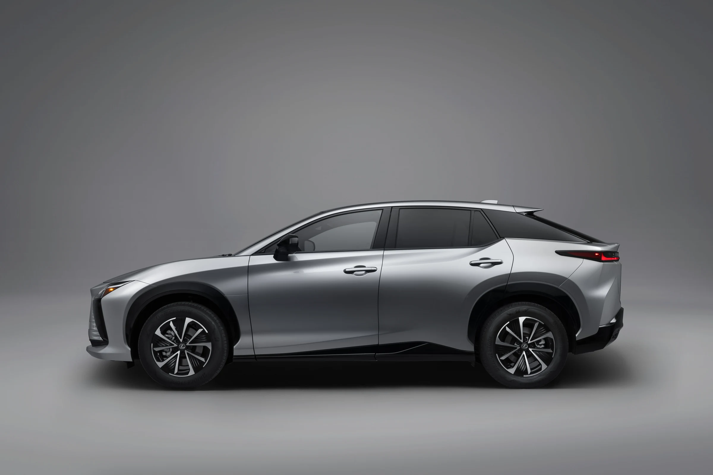 Perfil del Lexus RZ 350e FWD gris, con la línea del techo descendente y los rines de 18 pulgadas