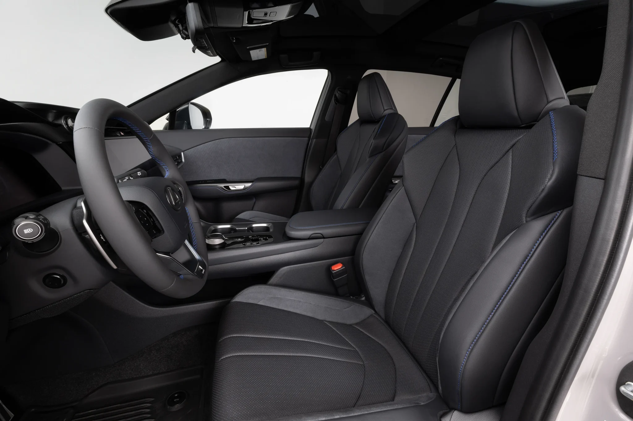 Asientos delanteros del Lexus RZ 550e F SPORT AWD en tono negro, con costuras azules y el volante al fondo