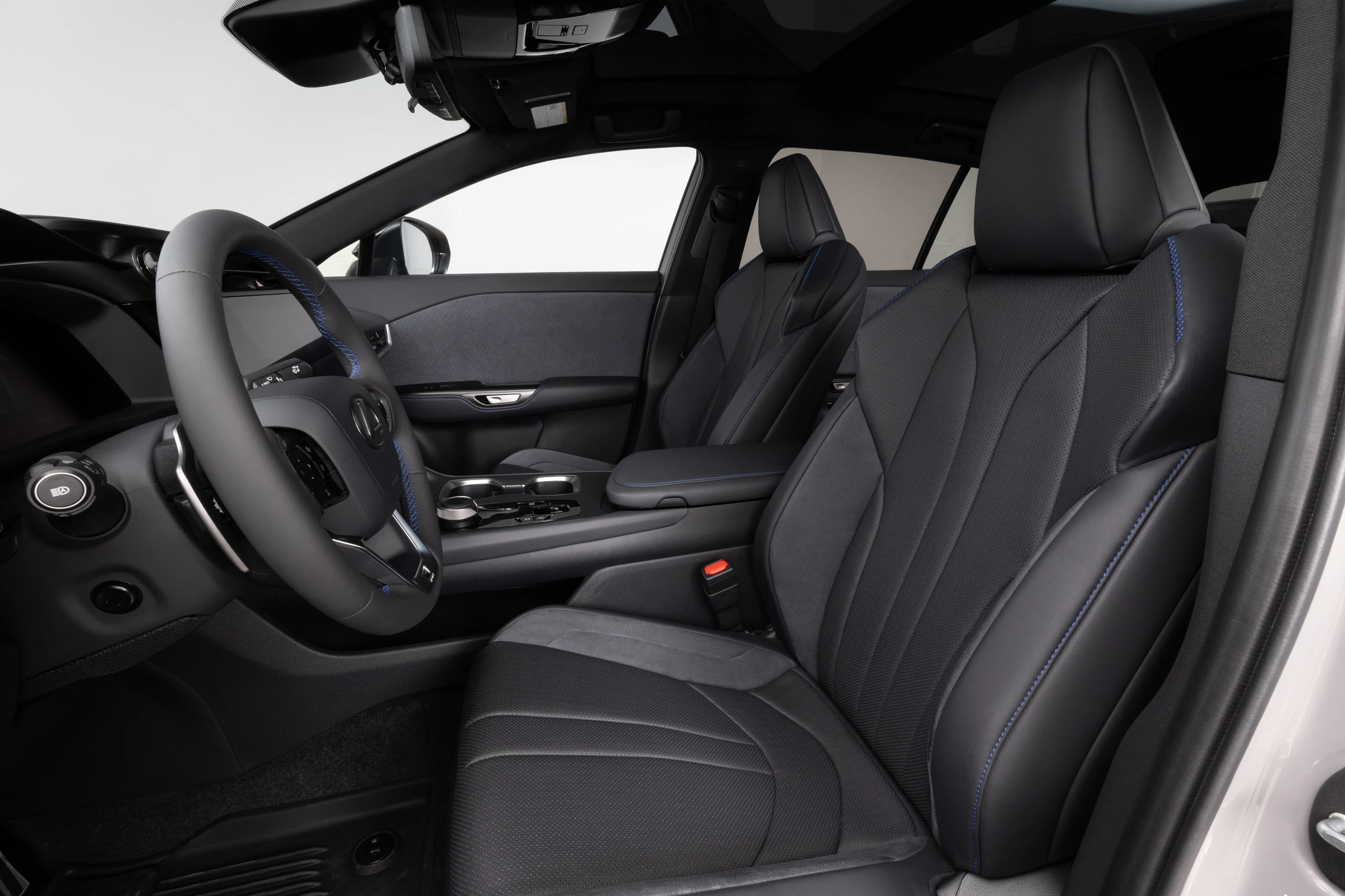 Asientos delanteros del Lexus RZ 550e F SPORT AWD en tono negro, con costuras azules y el volante al fondo