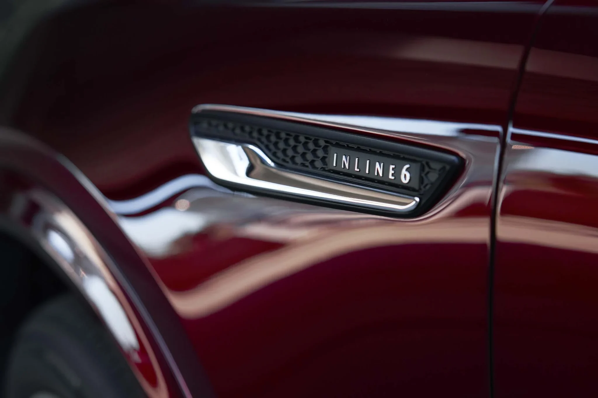 Insignia Inline 6 en el costado de un Mazda CX-90 rojo