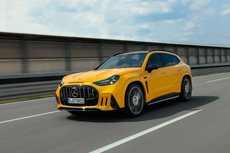 Mercedes-AMG GT SUV amarillo en movimiento sobre una pista, visto de frente y de costado