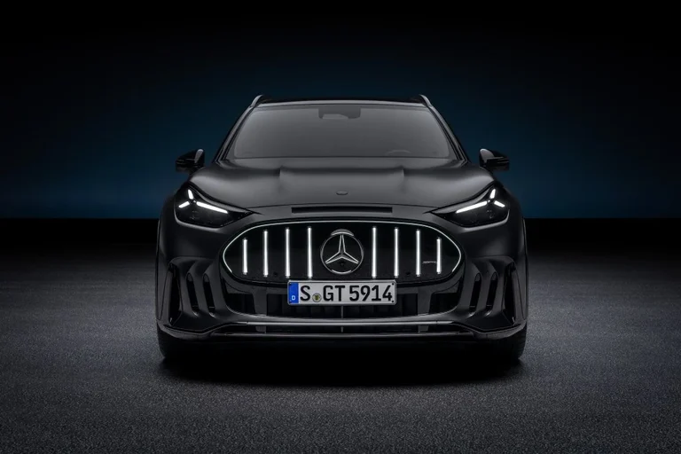 Frente del Mercedes-AMG GT SUV gris oscuro con la parrilla AMG iluminada y los faros delgados