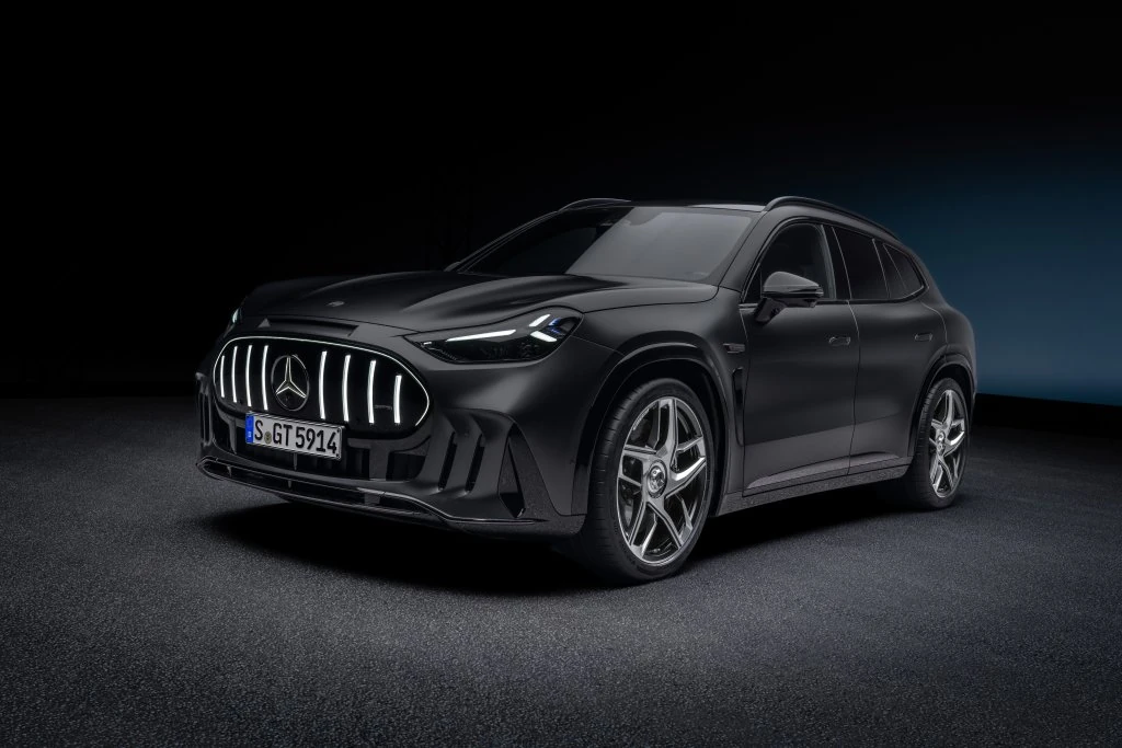 Mercedes-AMG GT SUV gris oscuro visto de frente y de costado en un estudio negro, con la parrilla vertical