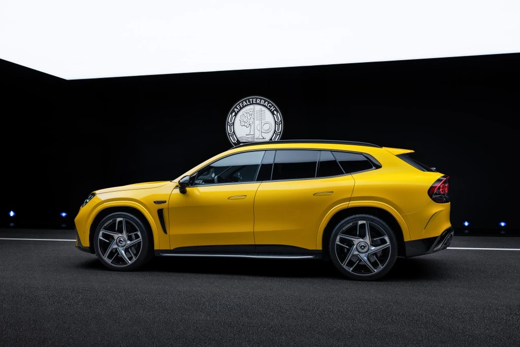 Perfil del Mercedes-AMG GT SUV amarillo con la línea de techo baja, en un estudio oscuro