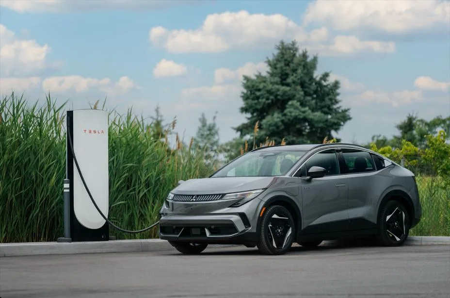 Mitsubishi Eclipse Sportback 2027 gris junto a un cargador rápido de corriente continua