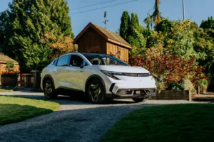Mitsubishi Eclipse Sportback 2027 blanco, vista frontal tres cuartos, estacionado en un camino de grava