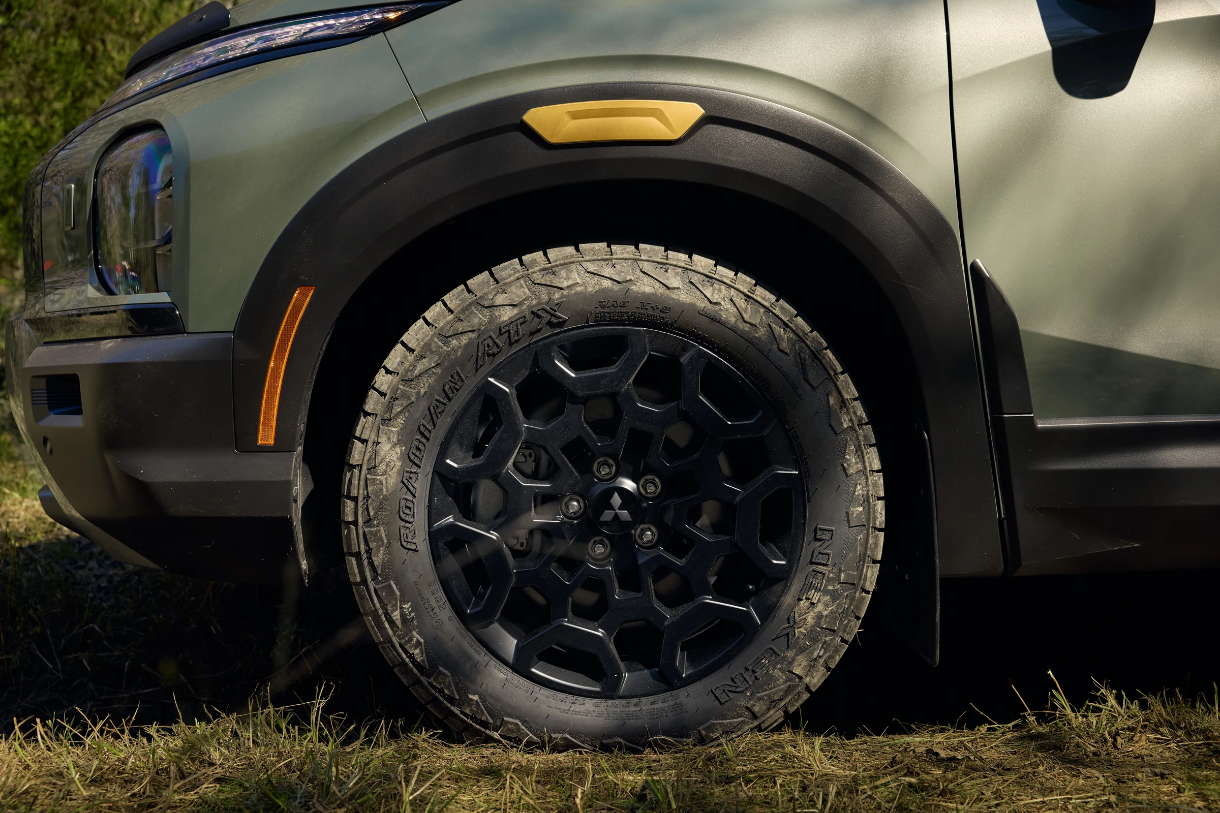 Detalle del Outlander Diamond Trail con el sobreguardabarros, el rin negro de 18 pulgadas y el neumático todoterreno