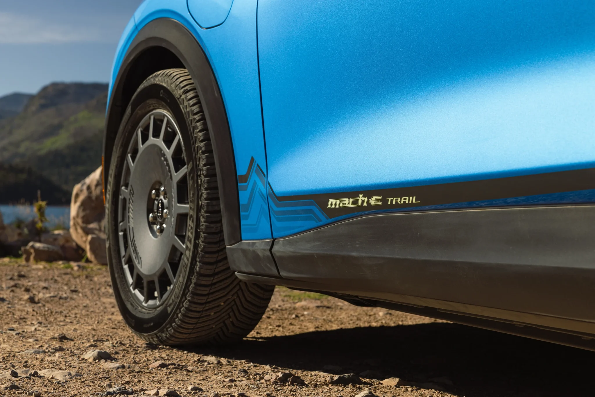 Rueda oscura de 19 pulgadas y rótulo Mach-E Trail en la parte baja de la puerta del Mustang Mach-E