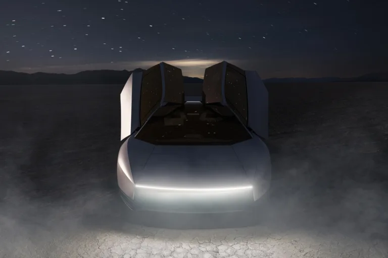 Nuevo Tesla Roadster blanco visto de frente, de noche en un salar, con las dos puertas abiertas hacia arriba