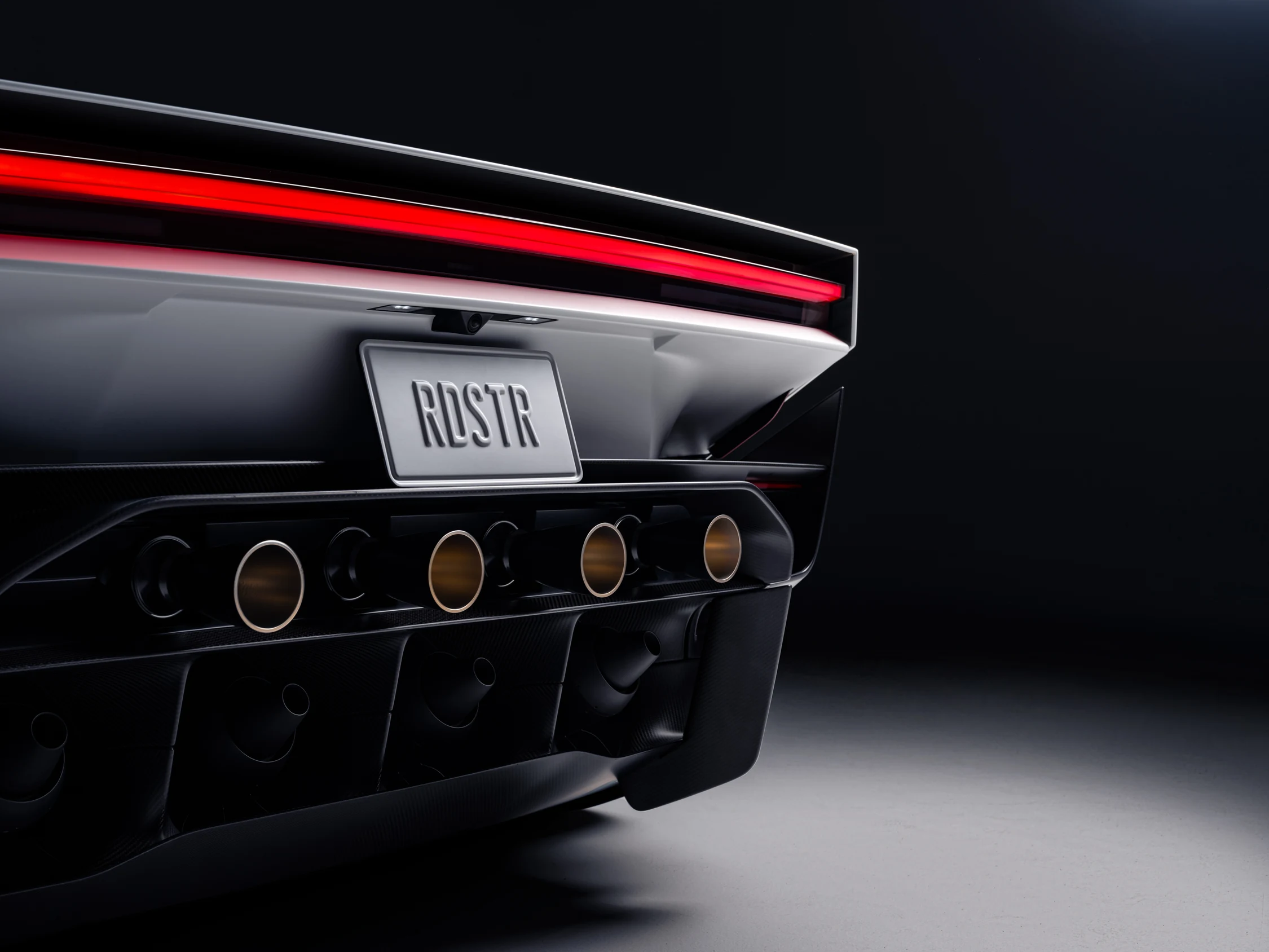 Parte trasera del nuevo Tesla Roadster con cuatro toberas doradas de los propulsores y la placa RDSTR