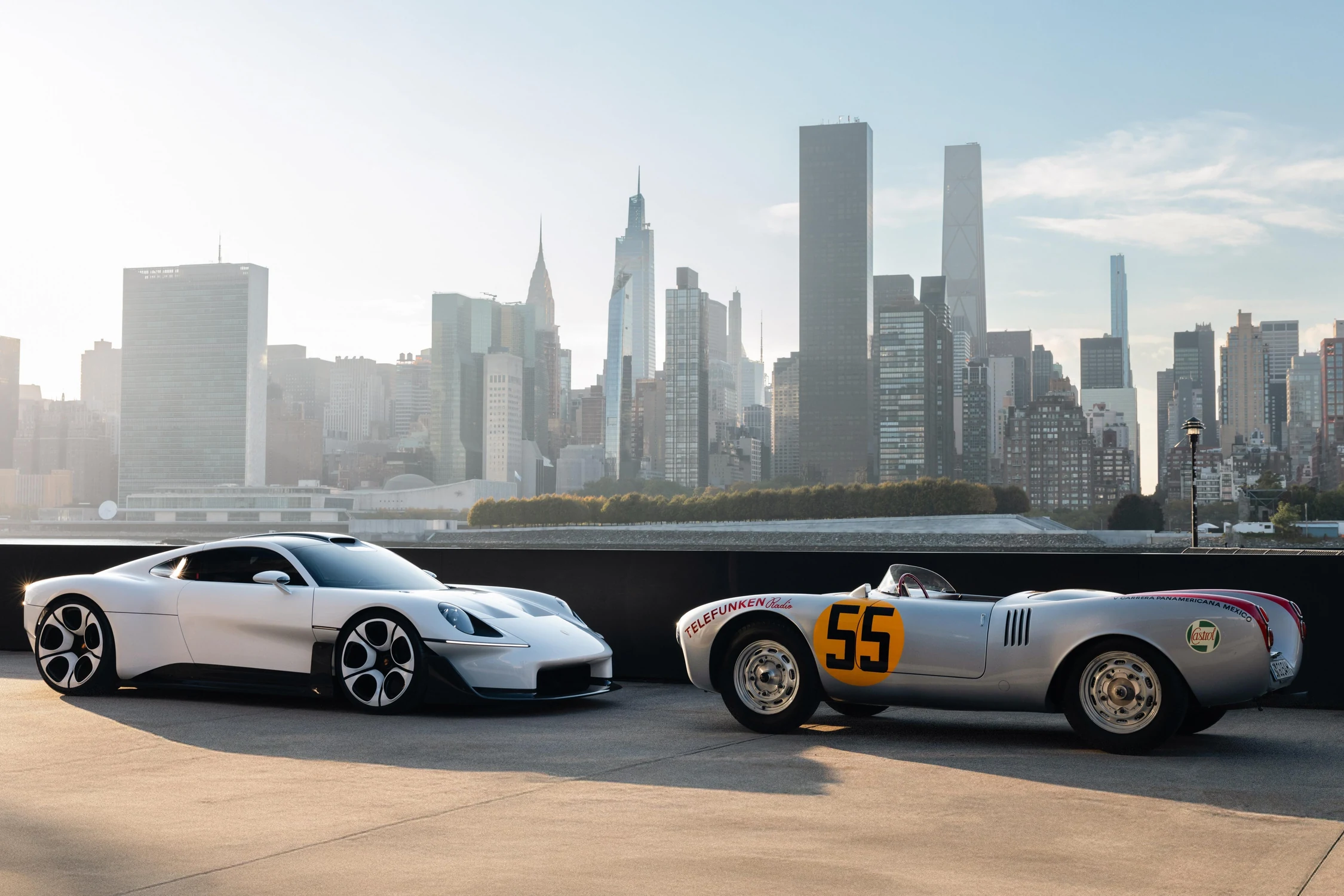 Porsche Mission S junto a un Porsche 550 Spyder de carreras con el número 55, frente a los edificios de Manhattan