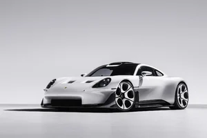 Porsche Mission S blanco visto de frente y de costado sobre fondo gris, con faros redondos y llantas de diseño nuevo
