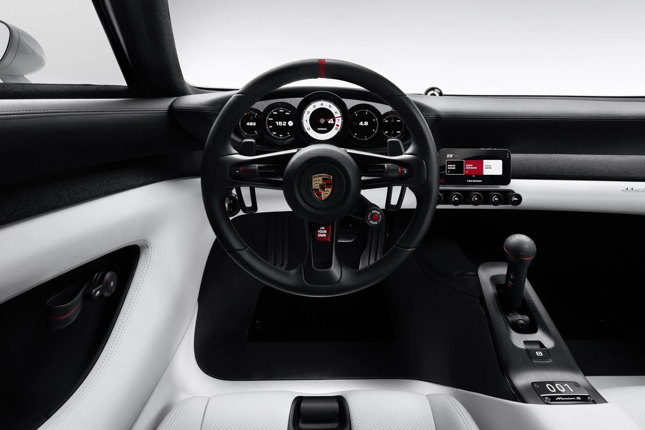 Interior del Porsche Mission S con volante, cinco instrumentos redondos, palanca de cambios y asientos blancos