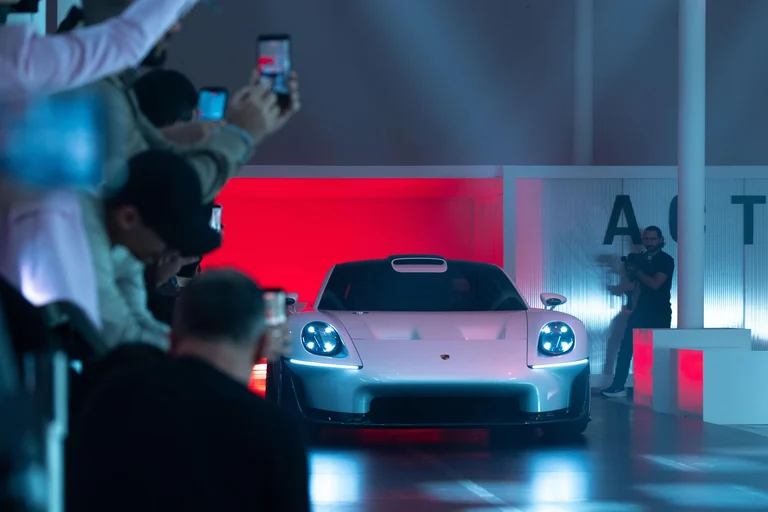 Porsche Mission S iluminado en una sala de presentación, con público tomando fotos con sus teléfonos
