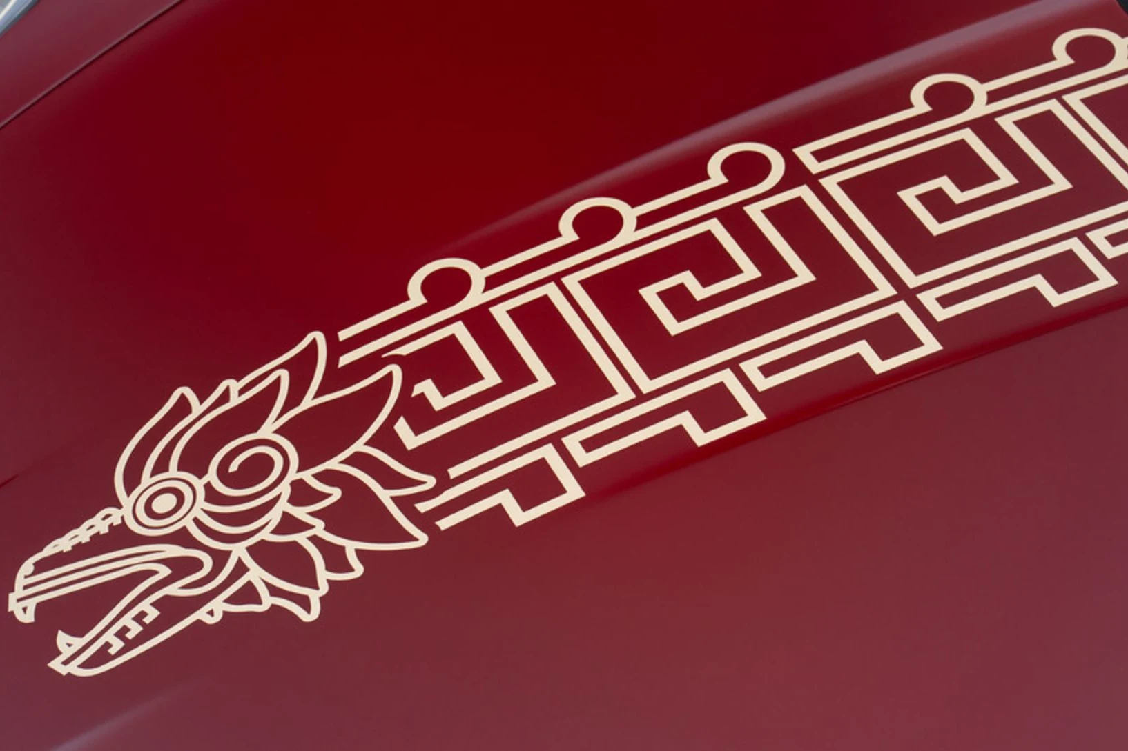 Quetzalcóatl dorado pintado a mano sobre el cofre rojo del Porsche 911 GT3 «La Serpiente», rodeado de patrones geométricos