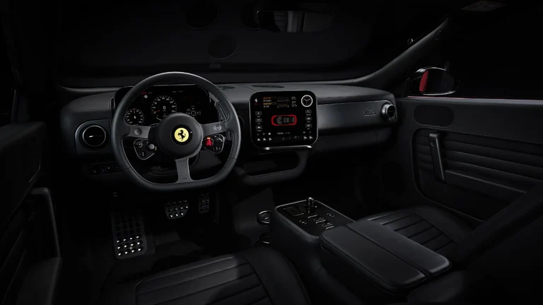 Interior en negro del Ferrari Luce con el volante, la pantalla central y la consola con botones mecánicos