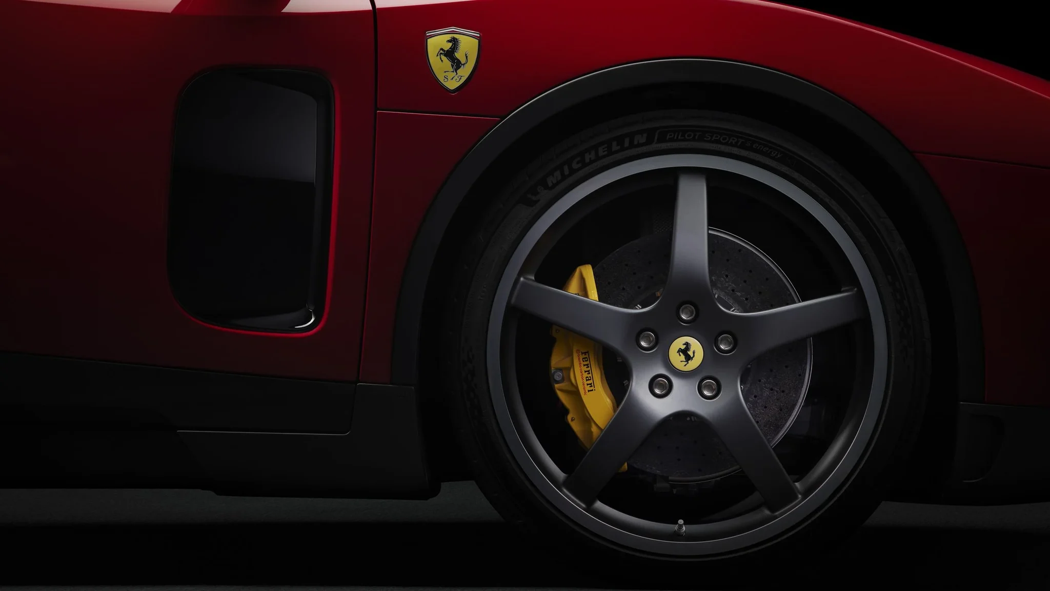 Rueda de cinco radios y pinza de freno amarilla del Ferrari Luce, con el escudo del Cavallino sobre el guardabarros