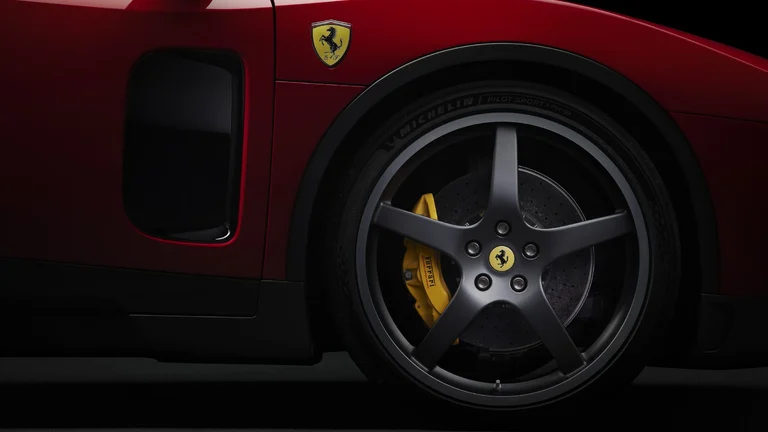 Rueda de cinco radios y pinza de freno amarilla del Ferrari Luce, con el escudo del Cavallino sobre el guardabarros