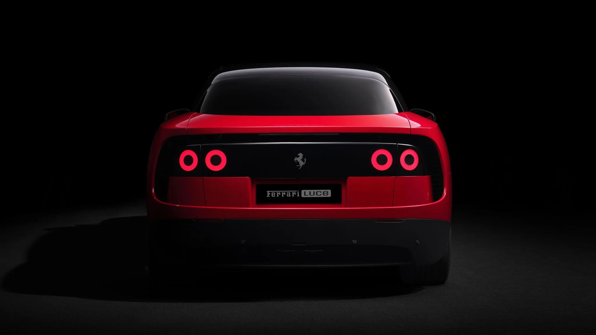 Parte trasera del Ferrari Luce con las luces circulares encendidas y la placa del modelo sobre fondo negro