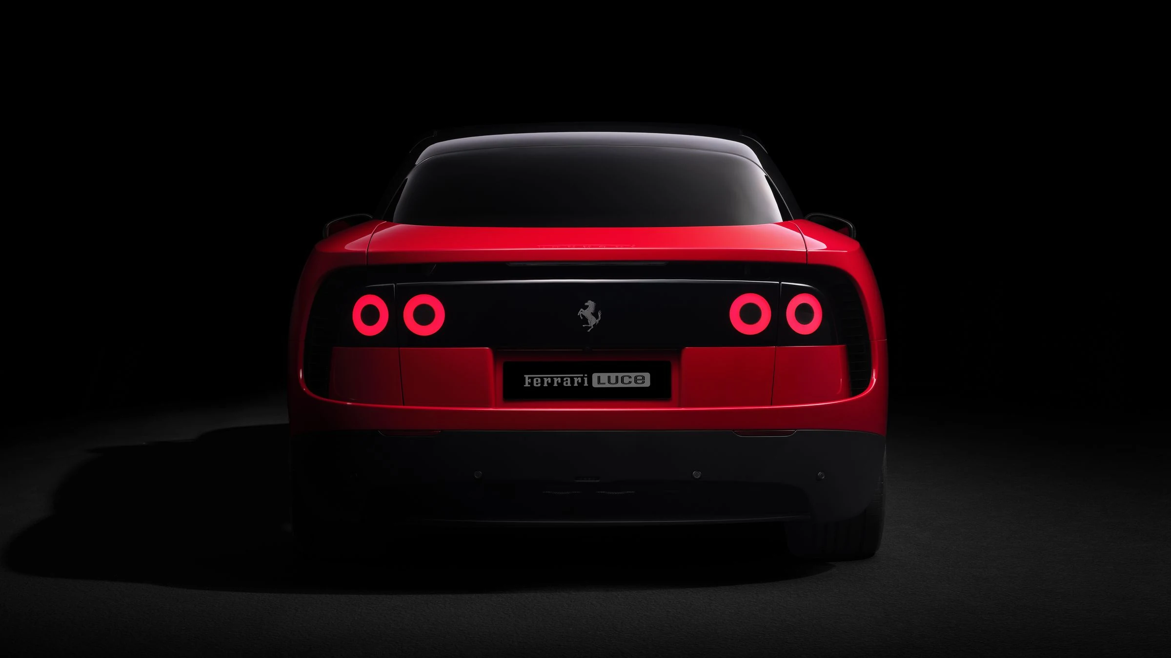 Parte trasera del Ferrari Luce con las luces circulares encendidas y la placa del modelo sobre fondo negro