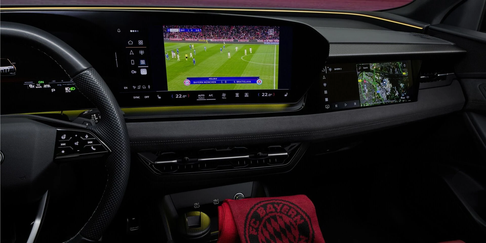 Audi Application Store: la pantalla central de un Audi muestra una transmisión de fútbol, junto al volante