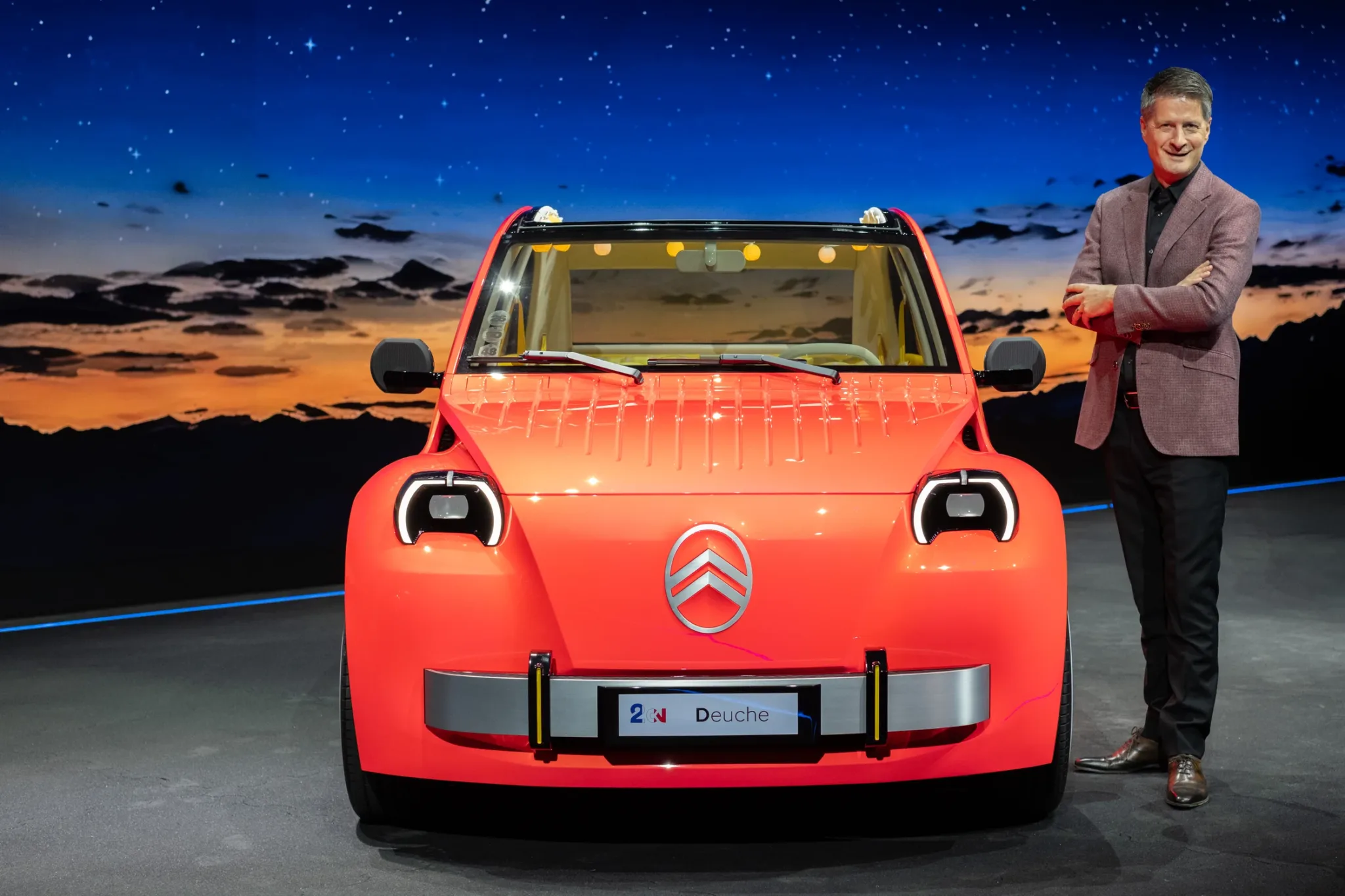 Citroën 2 CV Concept, eléctrico de color naranja rojizo, visto de frente con faros redondos