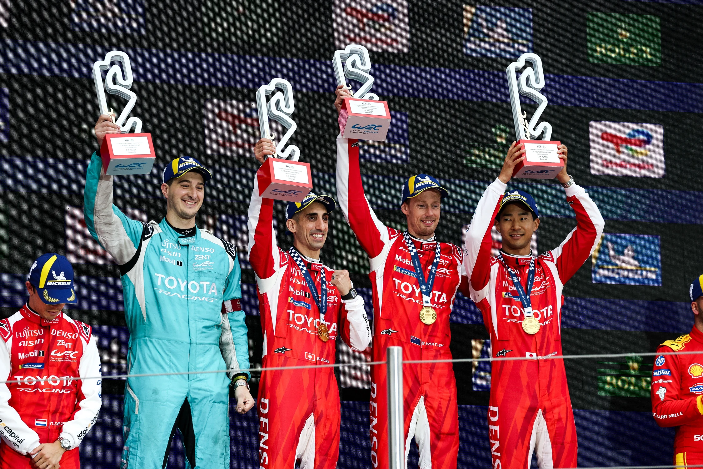 La tripulación del Toyota número 8 celebra en el podio de Barcelona con las medallas de oro y los trofeos en alto