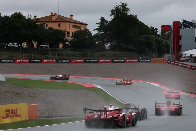 Toyota TR010 HYBRID y otros Hypercar entre la lluvia y el agua que levantan en una curva del circuito de Barcelona