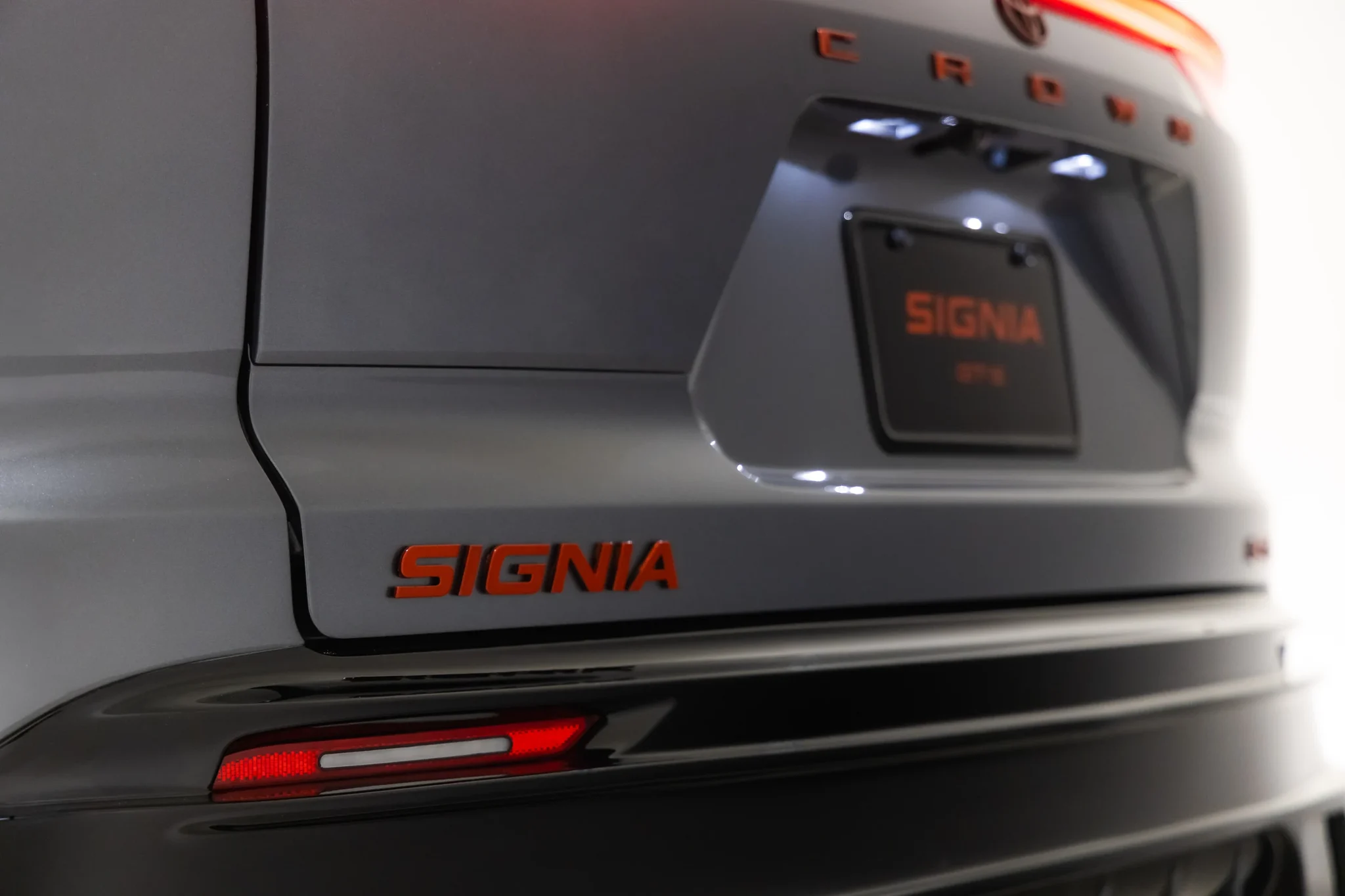 Compuerta trasera del Toyota Crown Signia GT-S con la palabra Signia en rojo y la luz trasera encendida