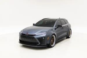 Toyota Crown Signia GT-S Concept gris oscuro visto de tres cuartos frontales, con rines dorados, sobre fondo blanco