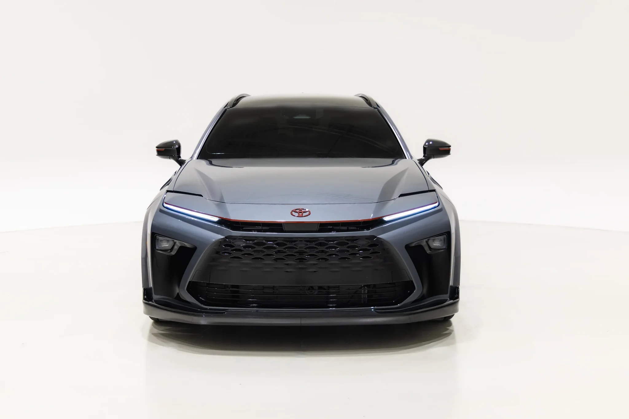 Frente del Toyota Crown Signia GT-S Concept, con la parrilla negra y la línea roja entre los faros