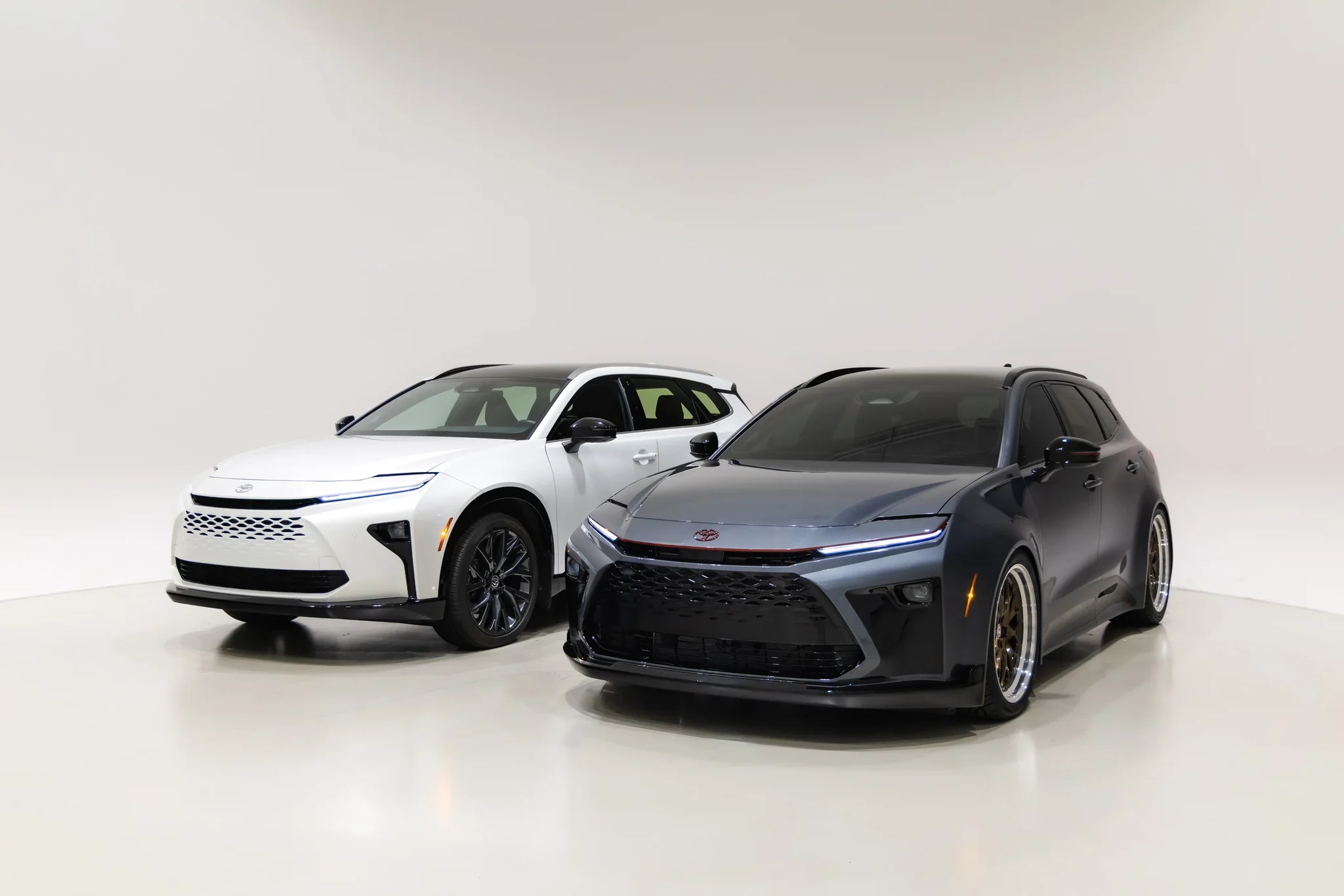 Toyota Crown Signia GT-S Concept junto a un Crown Signia blanco, de tres cuartos frontales, en un estudio
