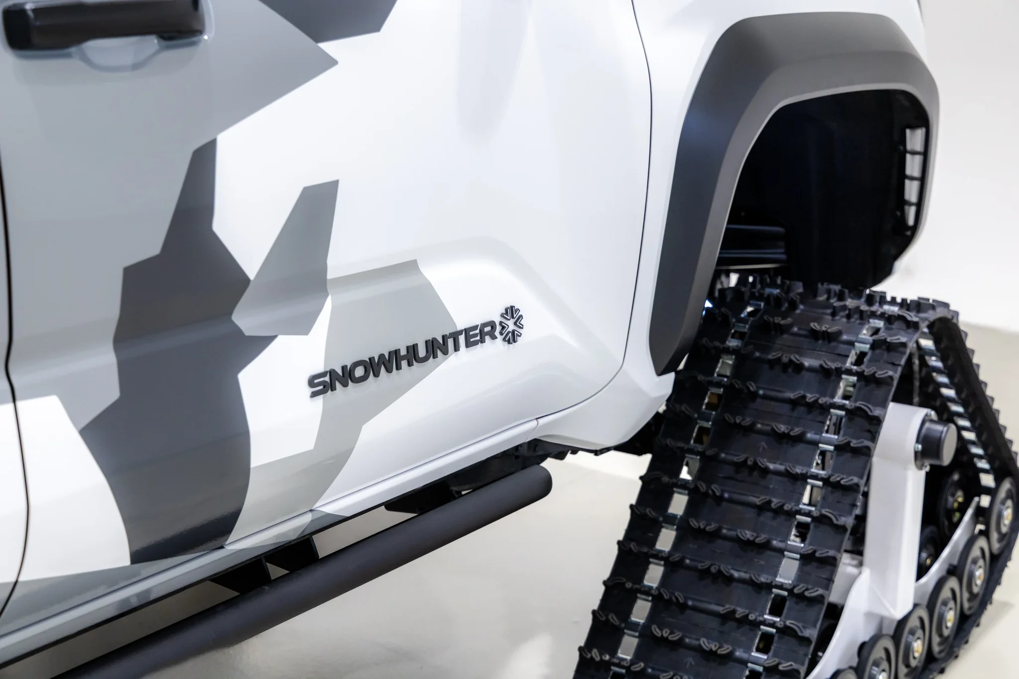 Detalle de la oruga blanca y del logotipo Snowhunter en la puerta de una 4Runner de Toyota con camuflaje