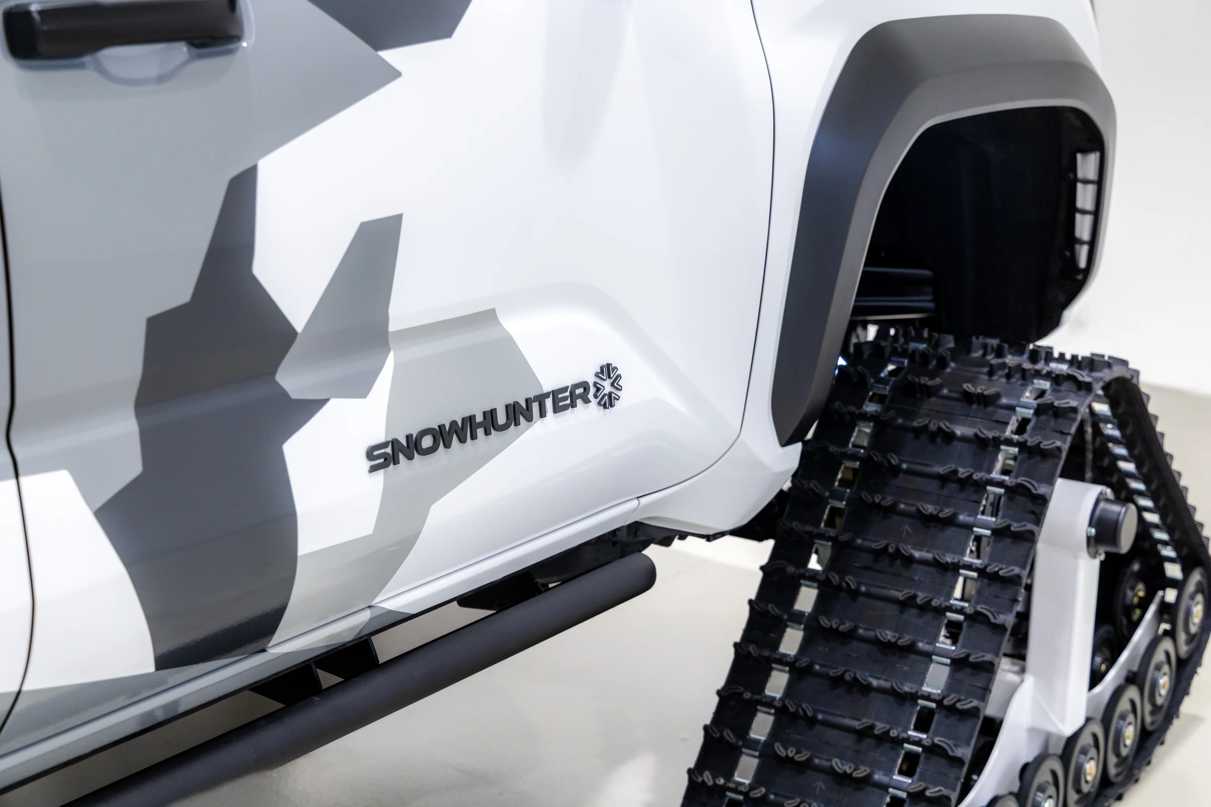 Detalle de la oruga blanca y del logotipo Snowhunter en la puerta de una 4Runner de Toyota con camuflaje