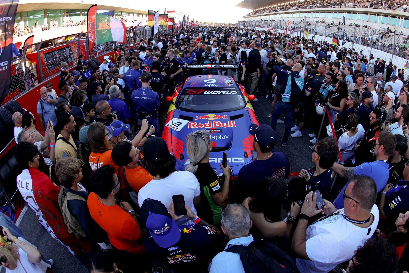Aficionados rodean al Mercedes-AMG GT3 número 3 de Verstappen Racing en Portimão, algunos con camisetas de Red Bull