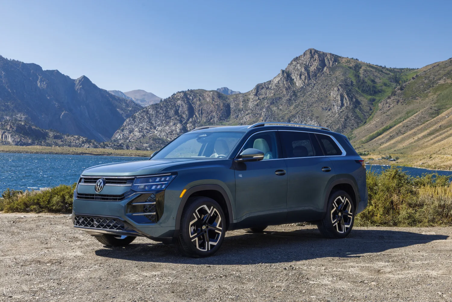 Volkswagen Atlas 2027 SEL Premium R-Line en color Sacramento Green junto a un lago